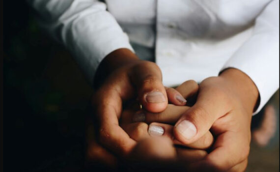 Close up of people holding hands in support