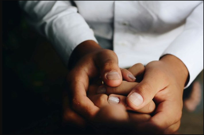 Close up of people holding hands in support