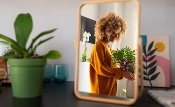 Smiling woman taking care of plants in her house