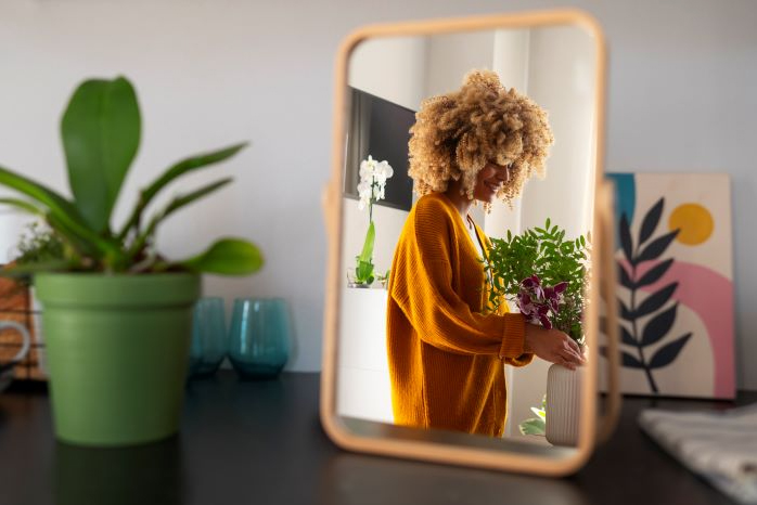 Smiling woman taking care of plants in her house